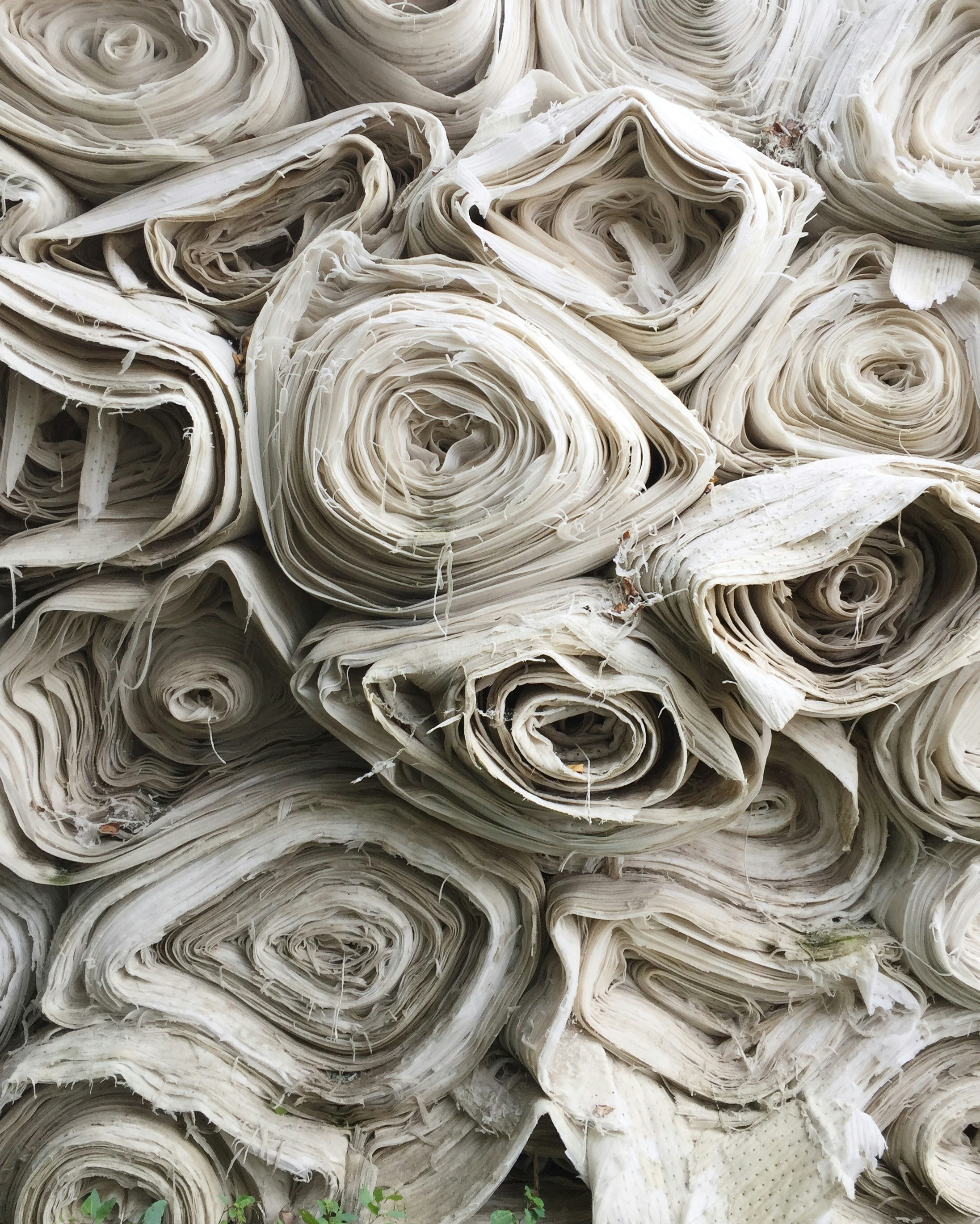 Large rolls of white fabric stacked on top of each other.